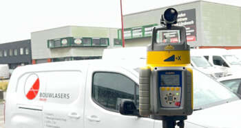 Scope gemonteerd op een gele Spectra GL412N afschotlaser op een statief, in gebruik op een bouwplaats.